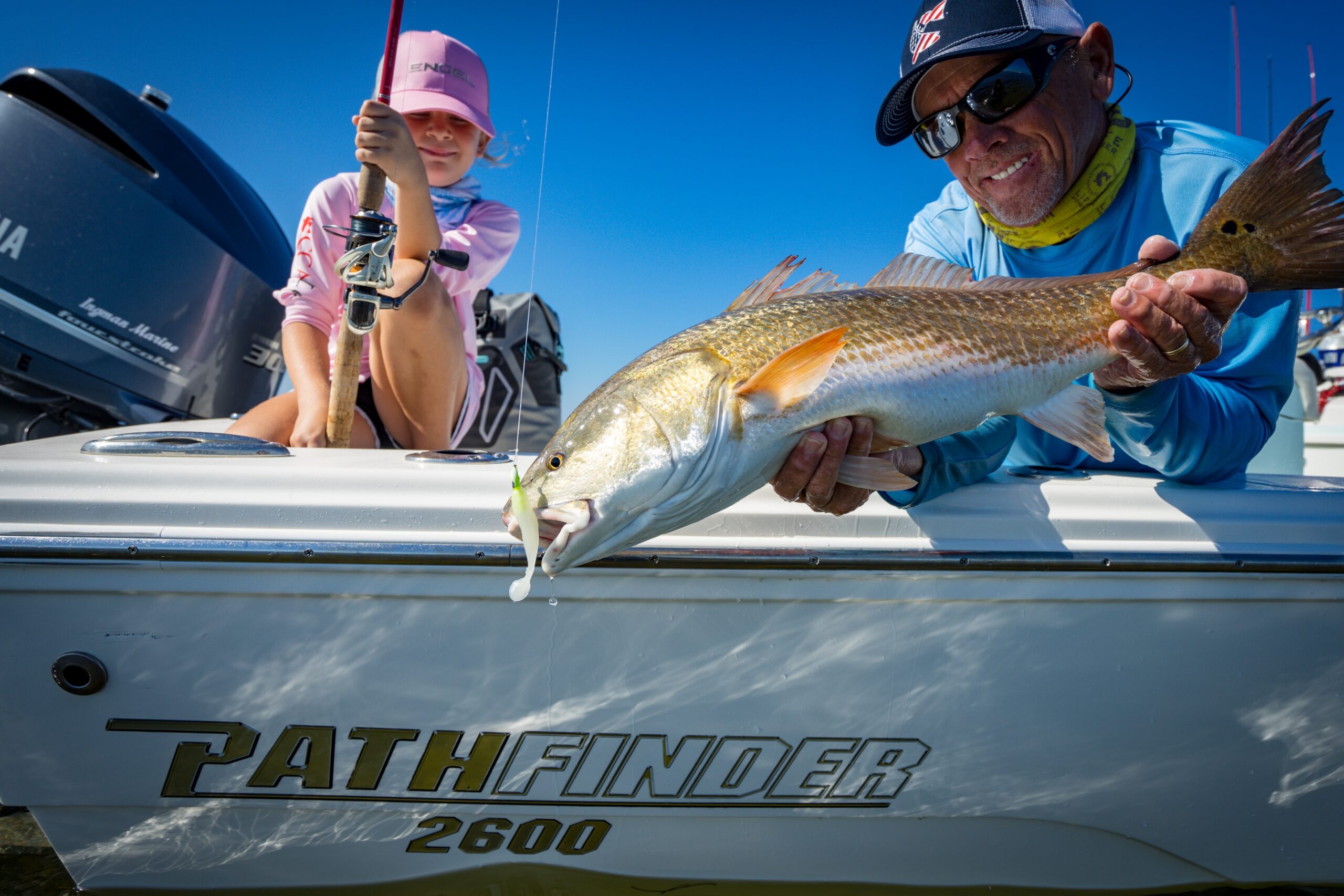 Dad holding daughters redfish on Pathfinder 2600 HPS.